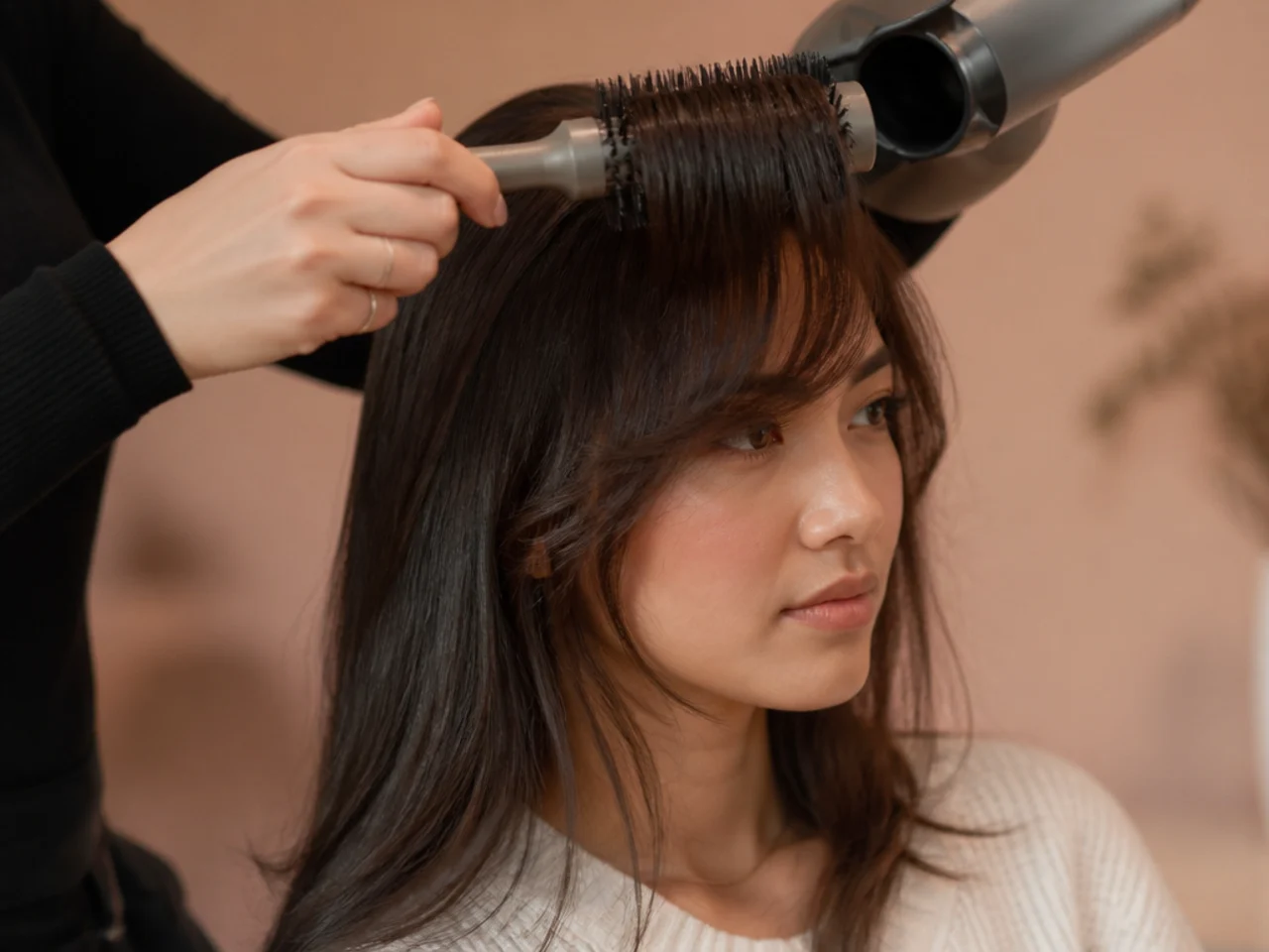 A round brush drying a fringe sideways at the root