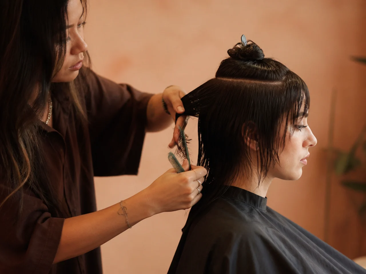 A stylist sectioning the crown before cutting a short wolf cut