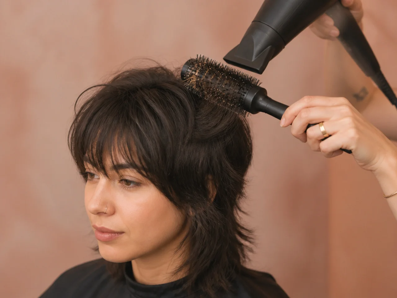 A short wolf cut being dried over a round brush at the crown