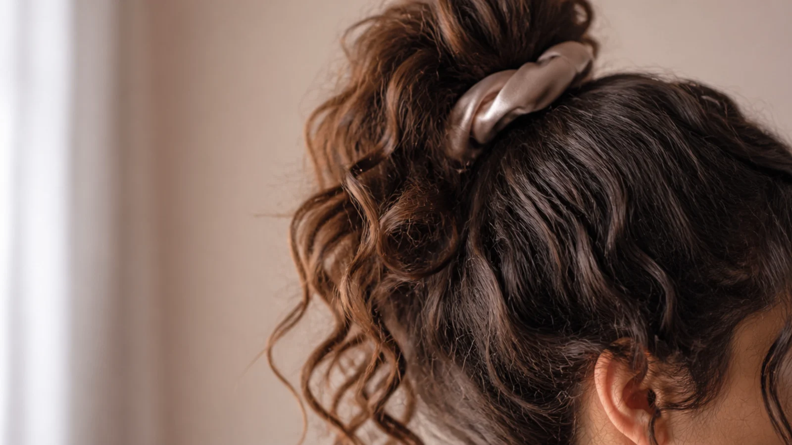 Curls piled high on the crown and secured with a soft scrunchie