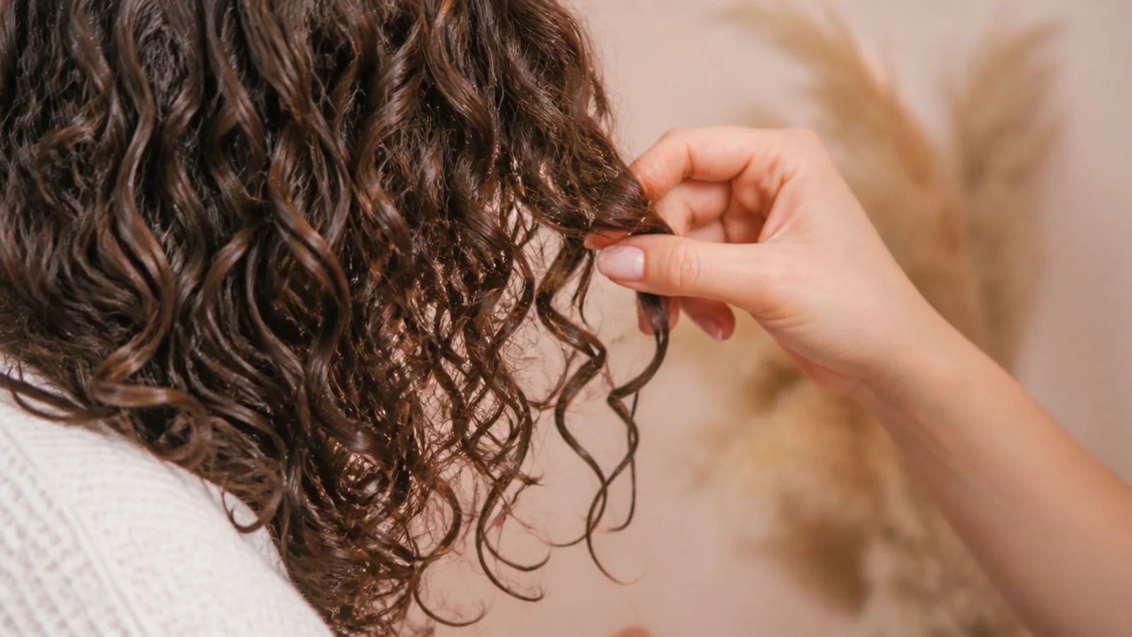 Hands cupping dry curls upward to break a gel cast