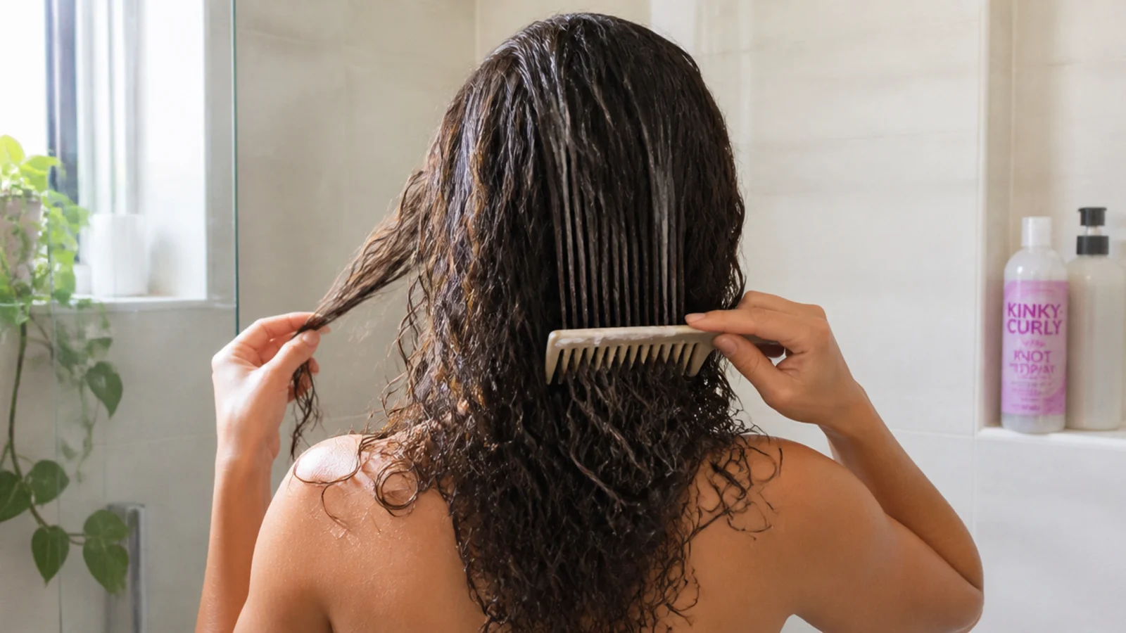 Wet curls being squished upward with cupped hands in the shower