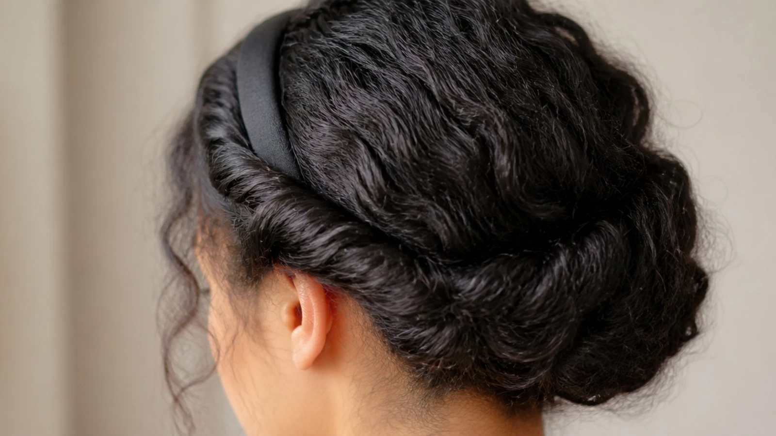 Hair rolled and tucked over an elastic headband at the nape