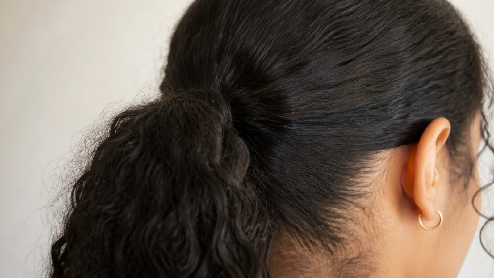 A smoothed low ponytail with the sides pulled flat against the head