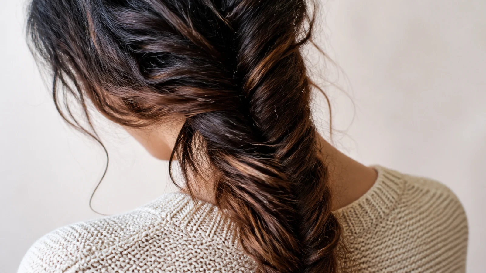 A fishtail braid worn over one shoulder against a light top