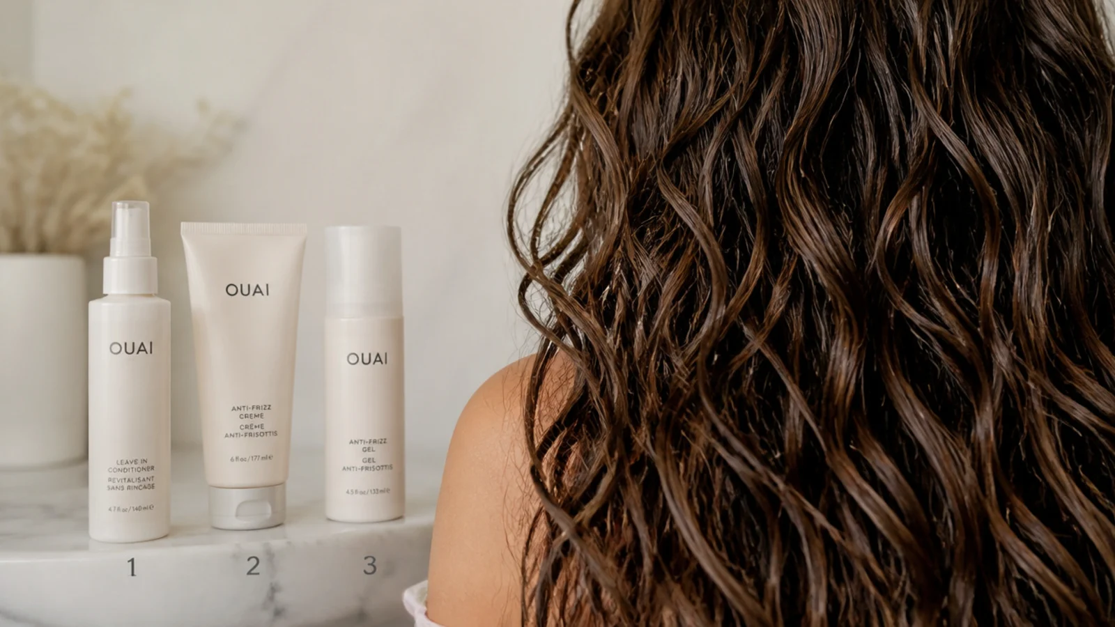 Three bottles arranged in application order beside a wet section of hair