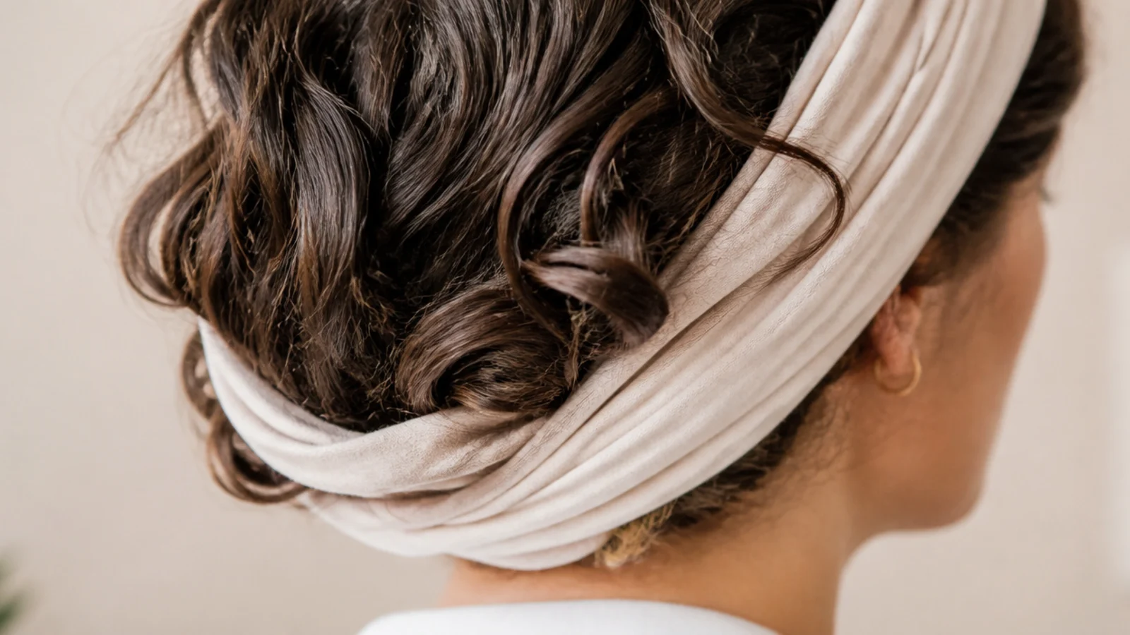 Hair piled and wrapped into a knotted grey t shirt on top of the head