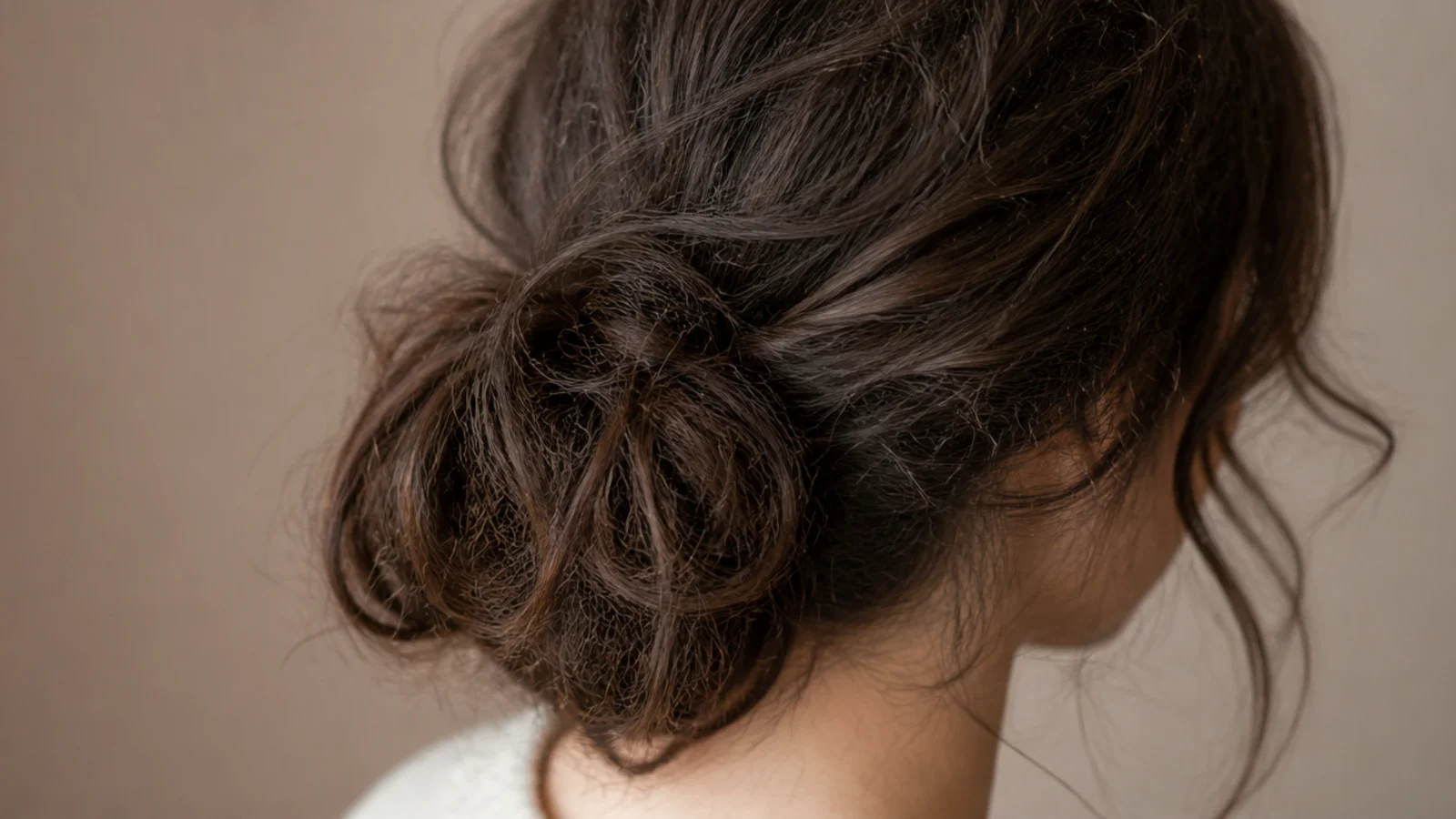 A loose high bun with soft pieces escaping around the ears