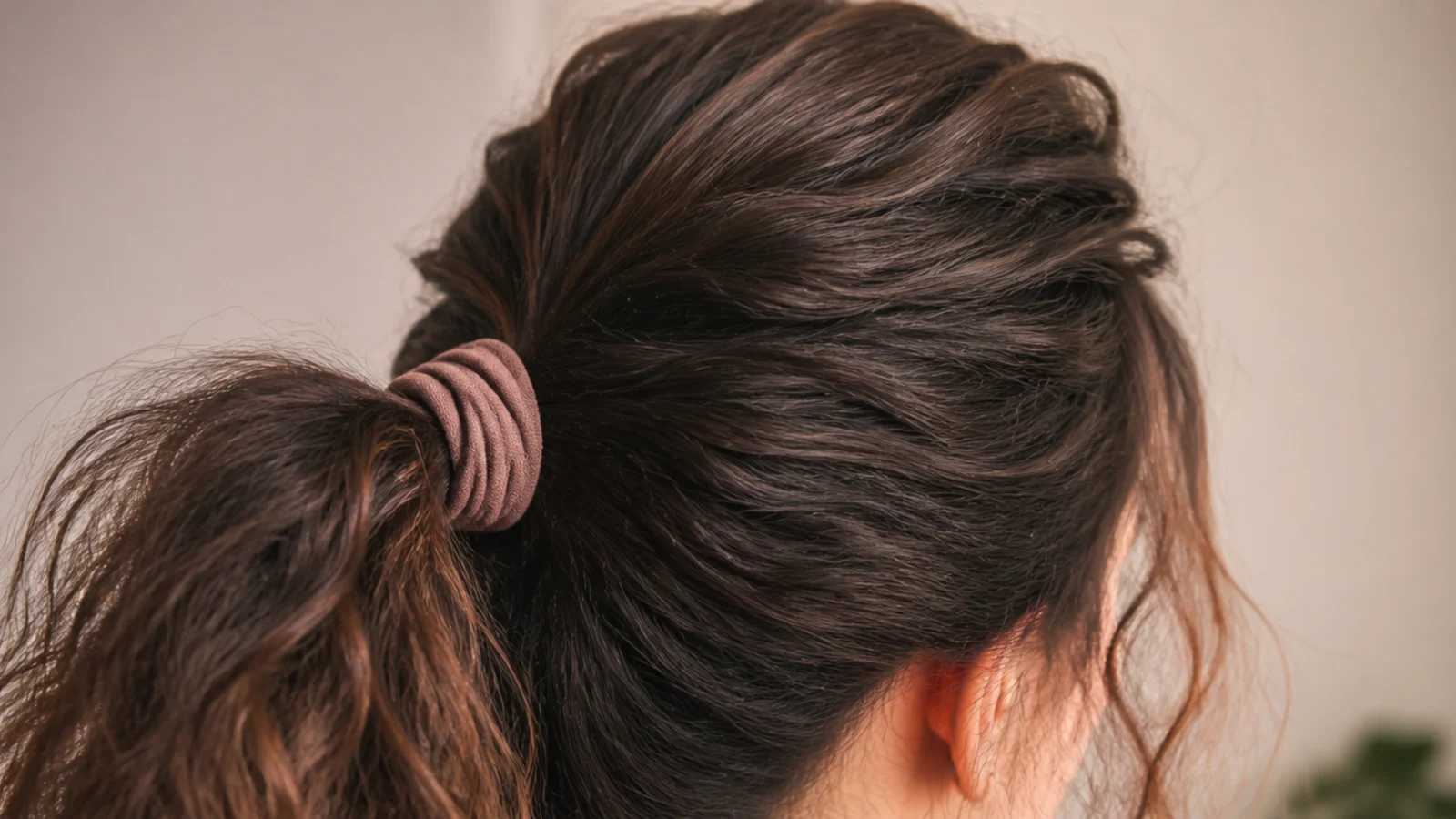 A ponytail with lifted volume through the crown and a smooth top layer