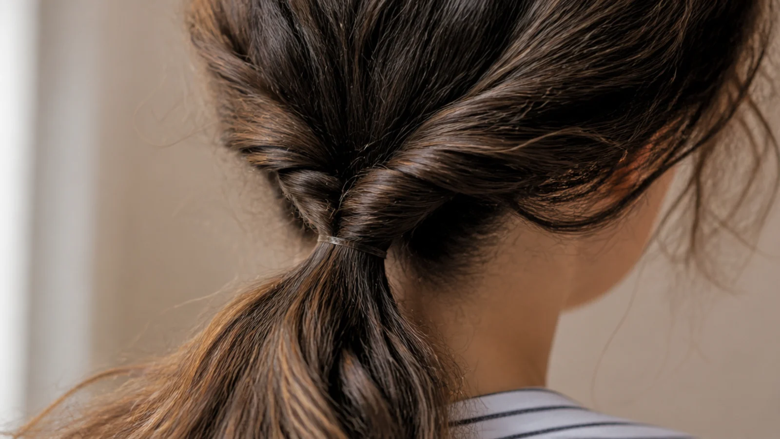 A rope twist falling from a mid height ponytail down the back