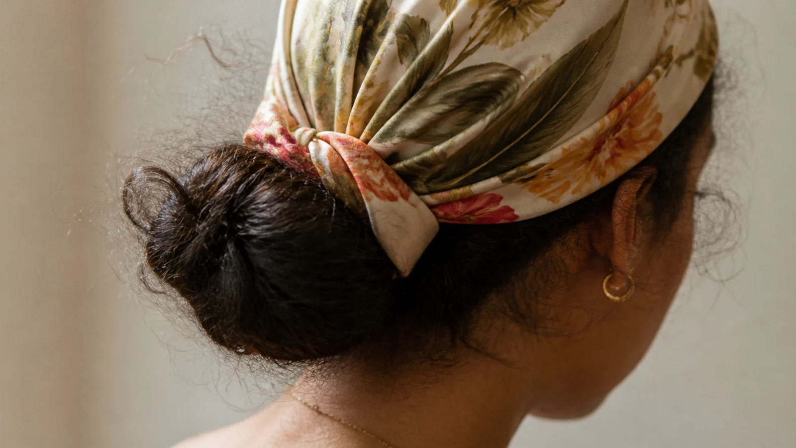 A patterned silk scarf wrapped fully over the front and tied at the back