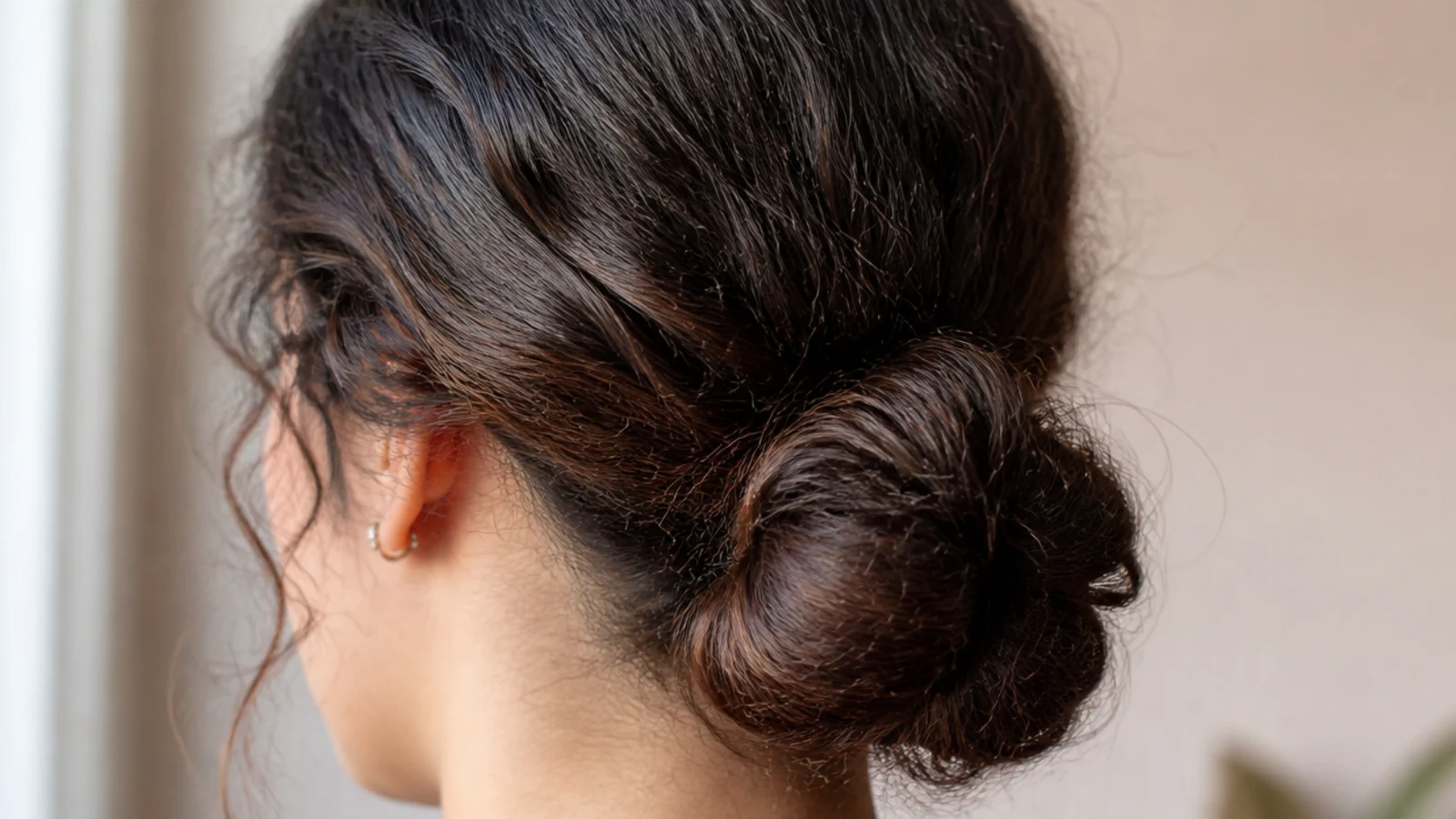 A rolled chignon pinned neatly at the nape of the neck