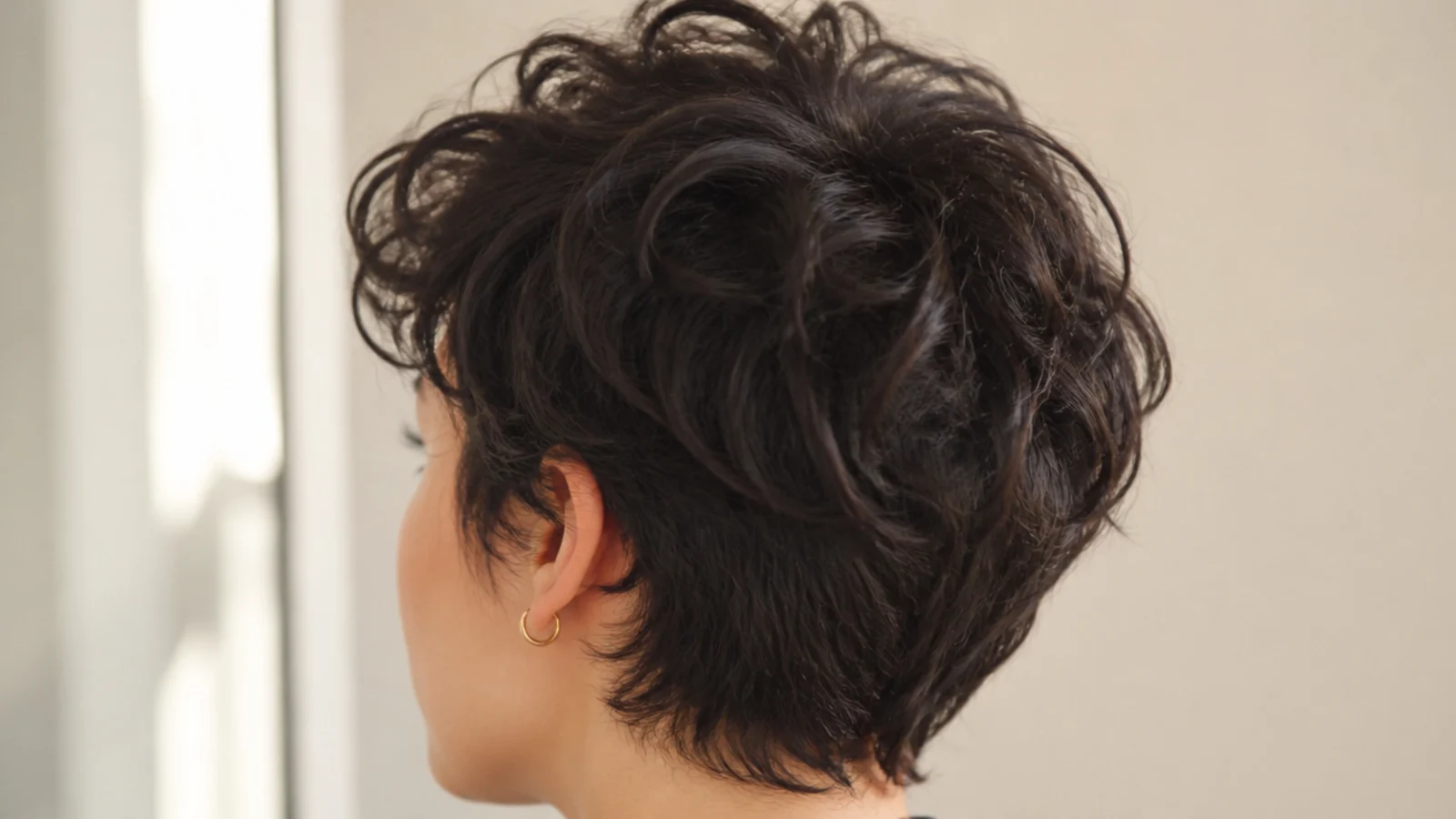 A short tousled pixie cut with piecey texture through the top