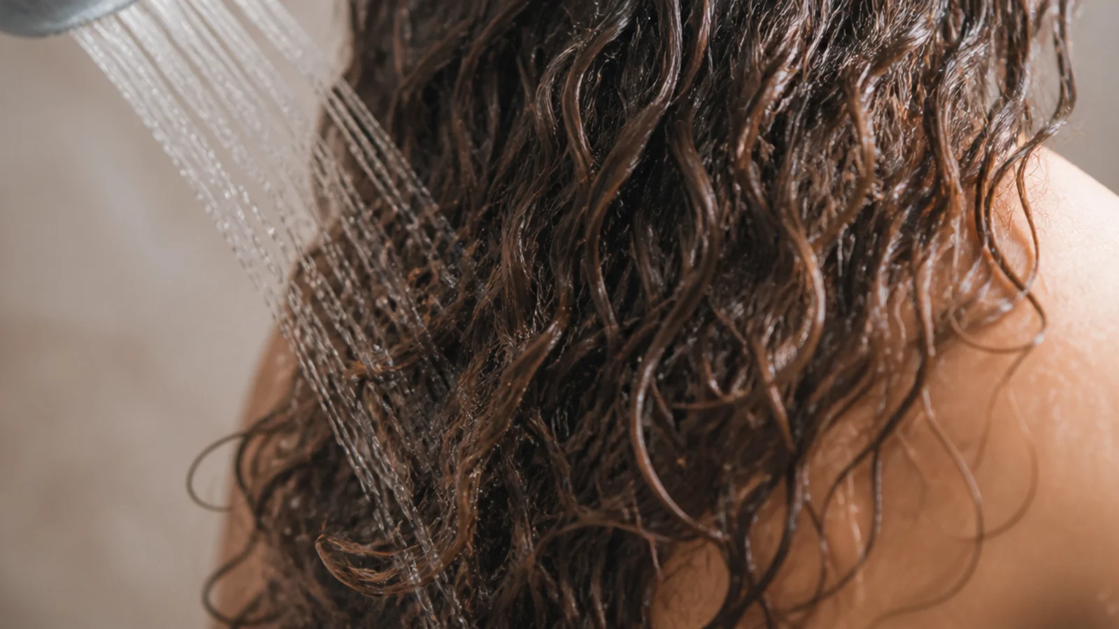 Cool water running over the length of dark hair at the end of a shower