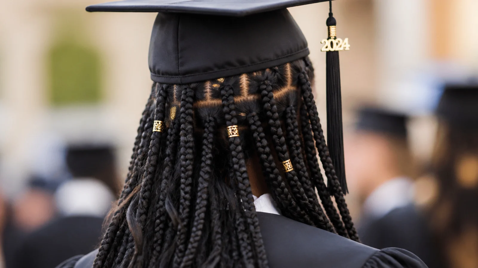 Fulani style braids with a centre part and small metal cuffs on the length