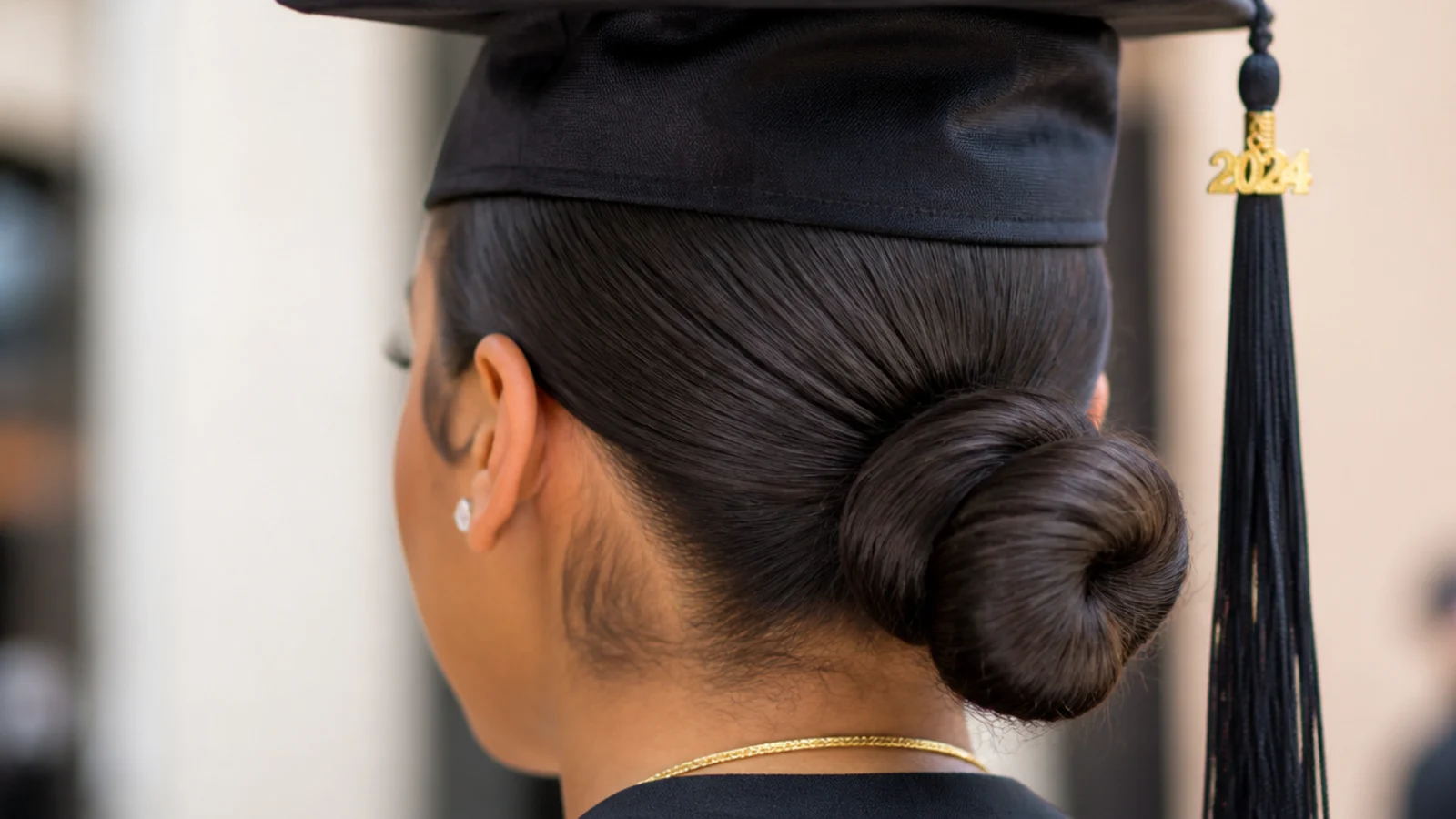 A tightly slicked bun with laid edges curving along the hairline