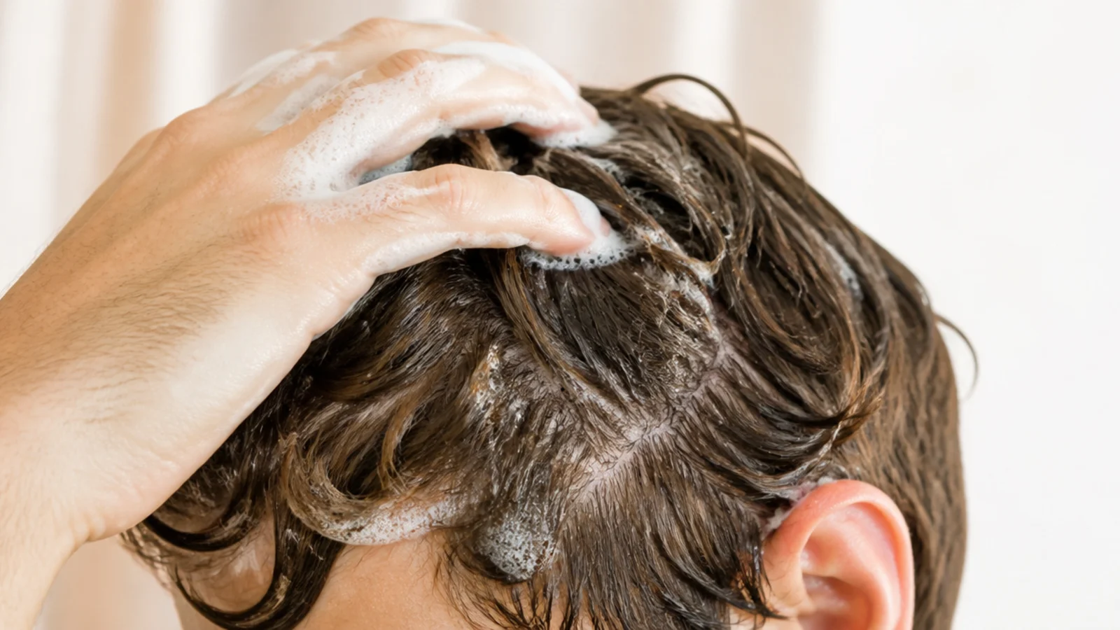 A gentle shampoo bottle in use at the shower