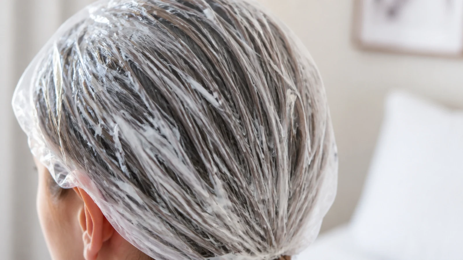A rich mask being smoothed over the ends of wet hair