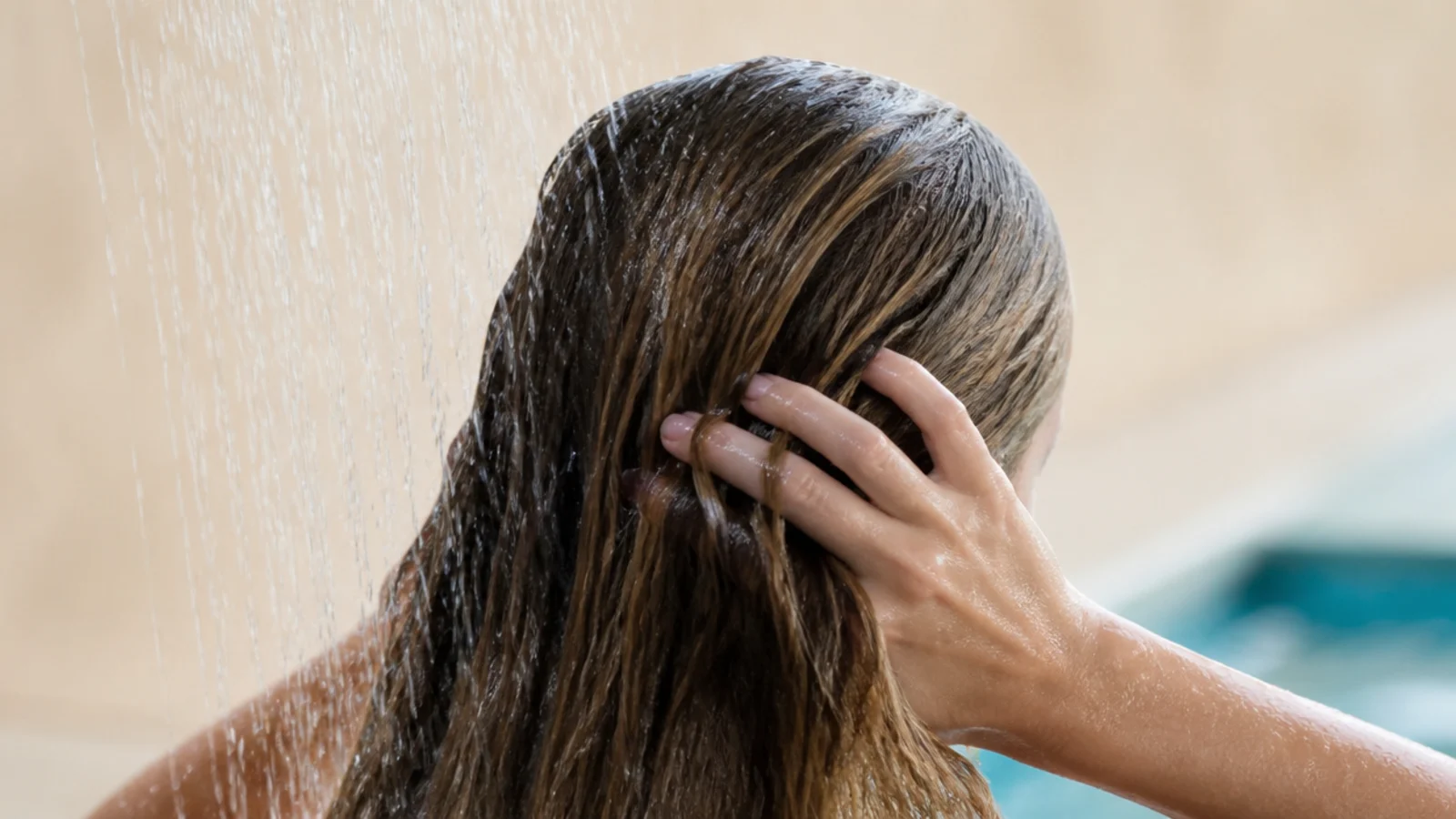 Hair being rinsed with fresh water at a poolside shower