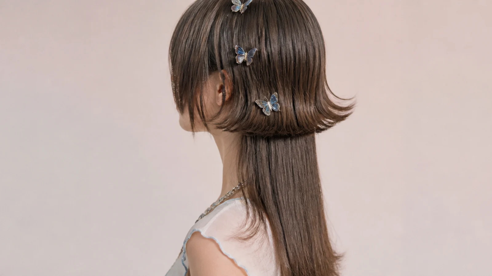 Small plastic butterfly clips holding the top layer back at both temples