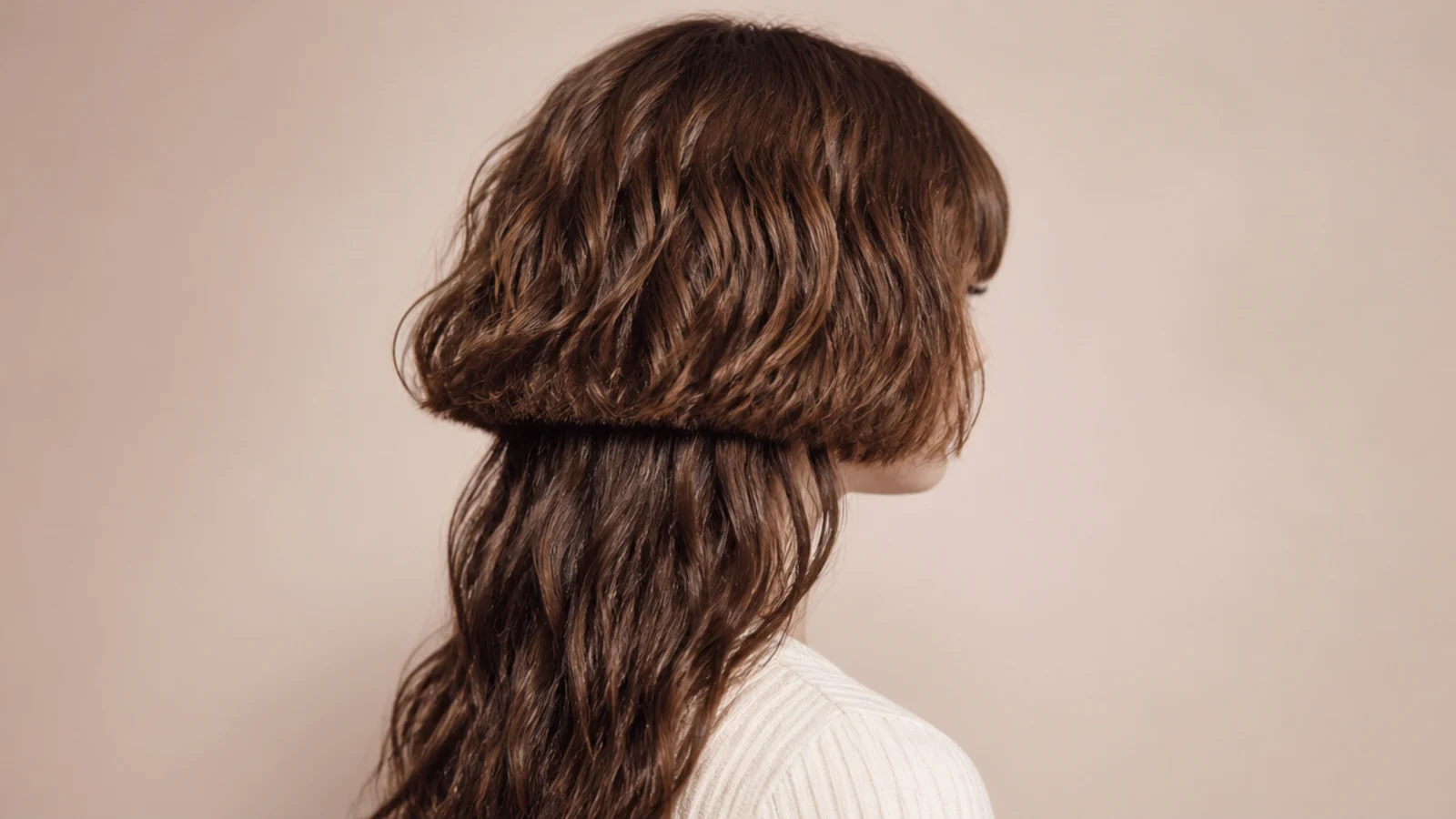 Loose waves forming a chin length rounded layer above longer wavy hair
