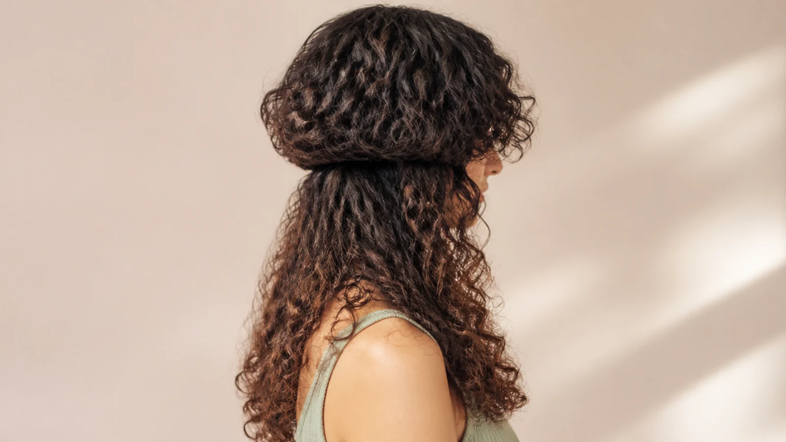 Curly curtain bangs parted in the middle over the forehead