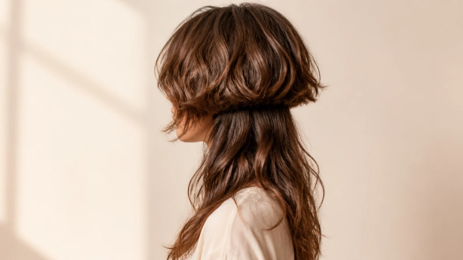 Fine wavy hair cut into a solid rounded top layer above thin lengths