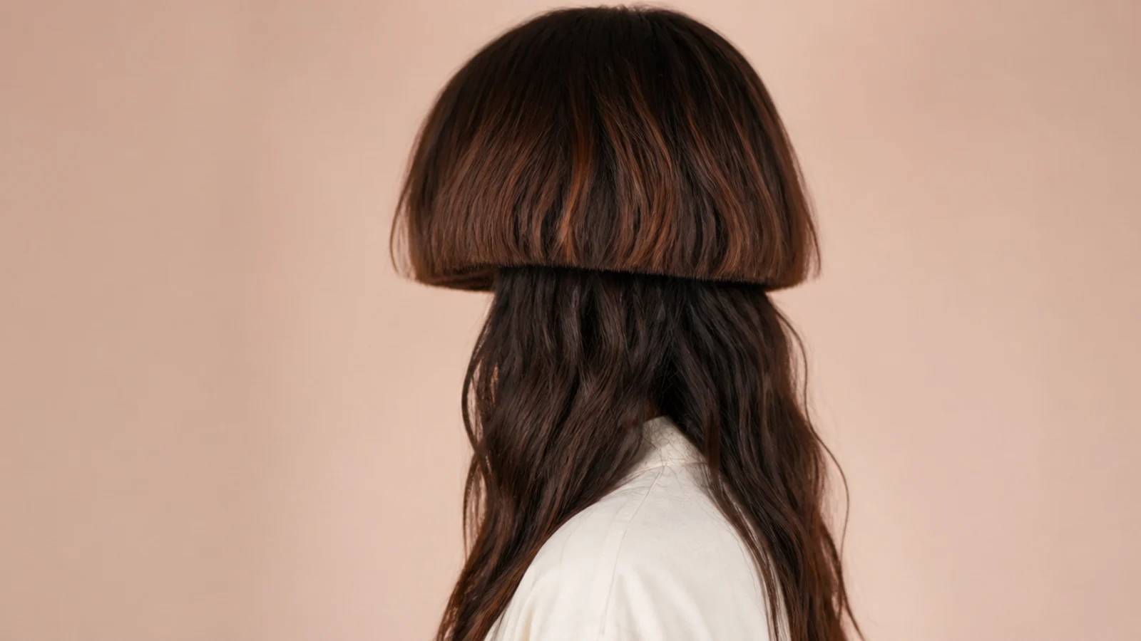 Loosely waved hair with a pressed straight edge across the top layer