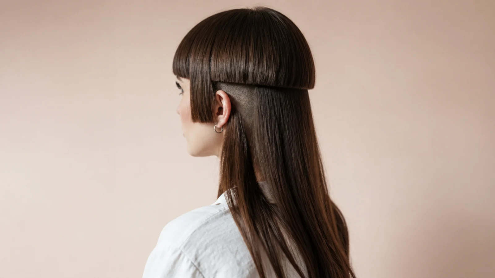 Very short bangs above a rounded layer with clipped hair visible at the neck