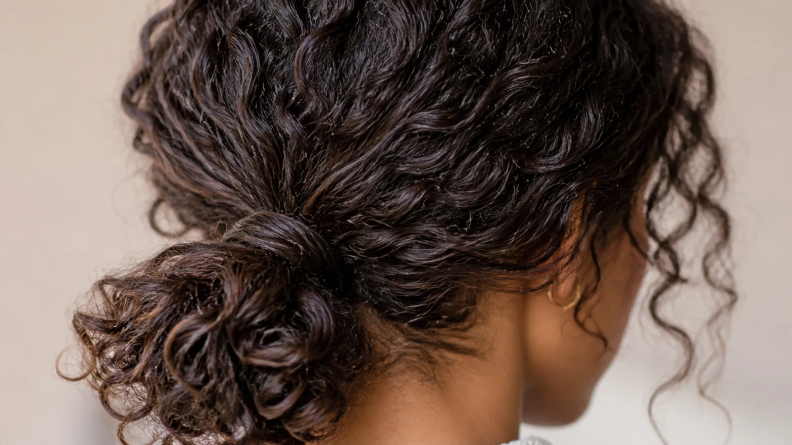 Spiral curls gathered loosely into a low ponytail at the nape