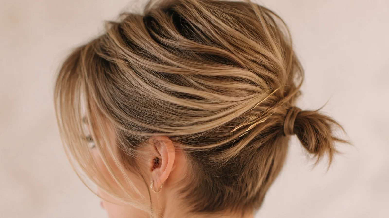 A grown out pixie gathered into a small stub at the nape