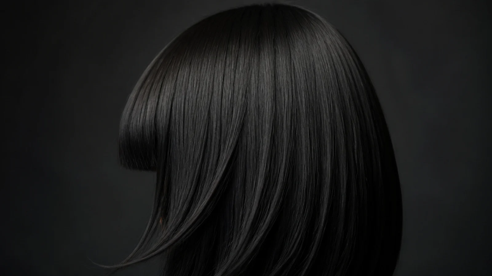 Jet black hair with a heavy straight cut fringe across the brow
