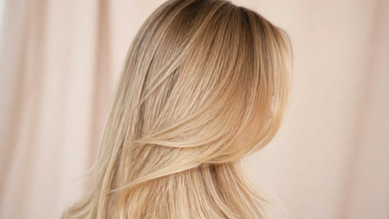 Warm blonde lengths with a deeper root blended at the parting