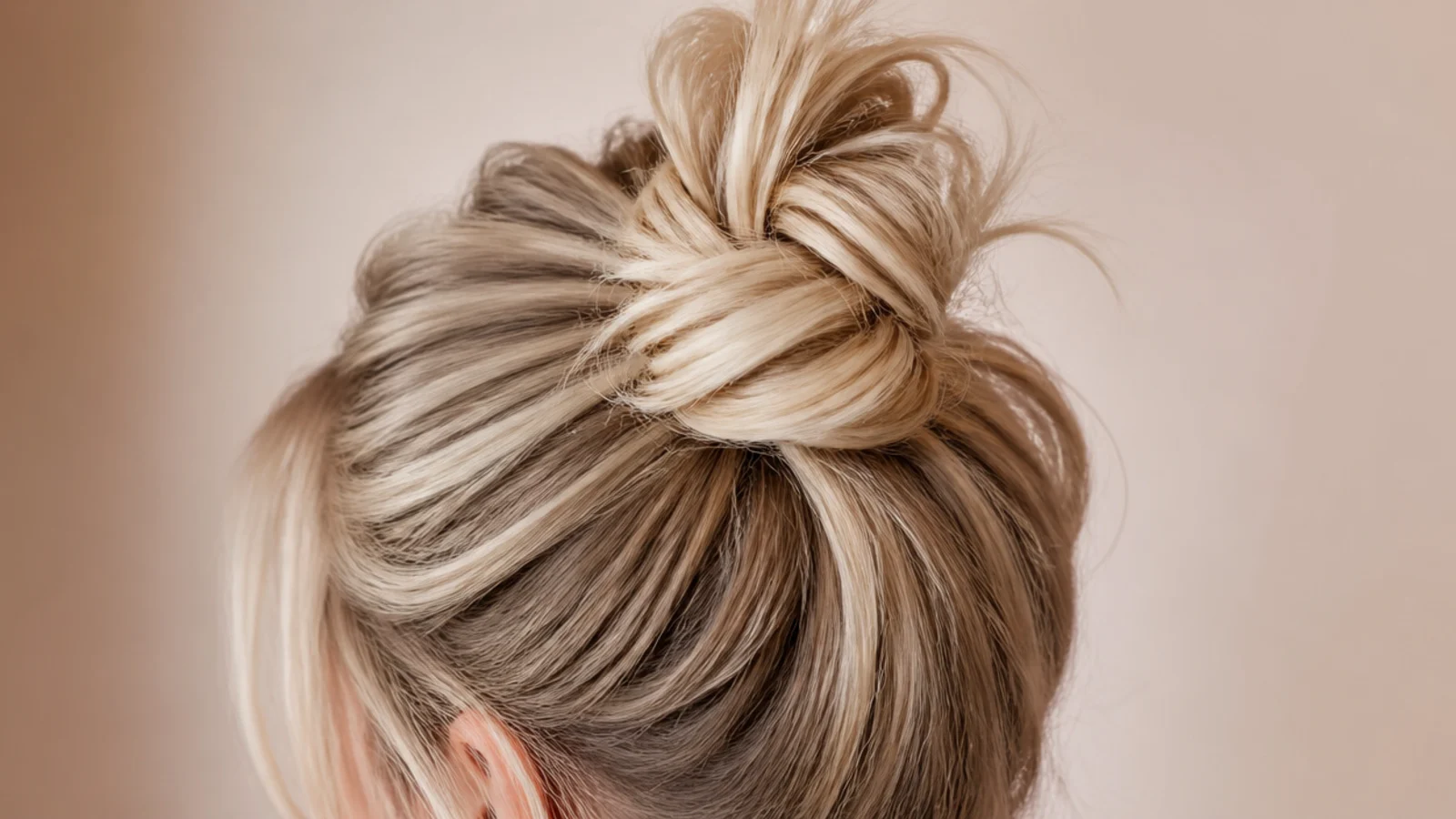 A small top knot sitting high on the head with a smooth base