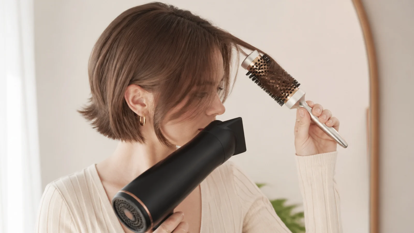 A small round brush drying a short fringe under a nozzle