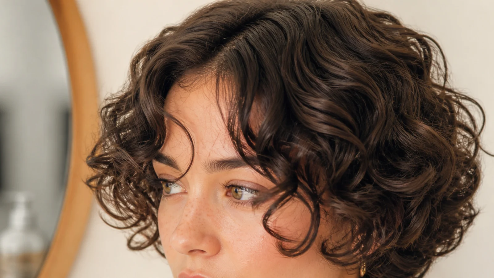 Curly hair with a short fringe curling above the brows